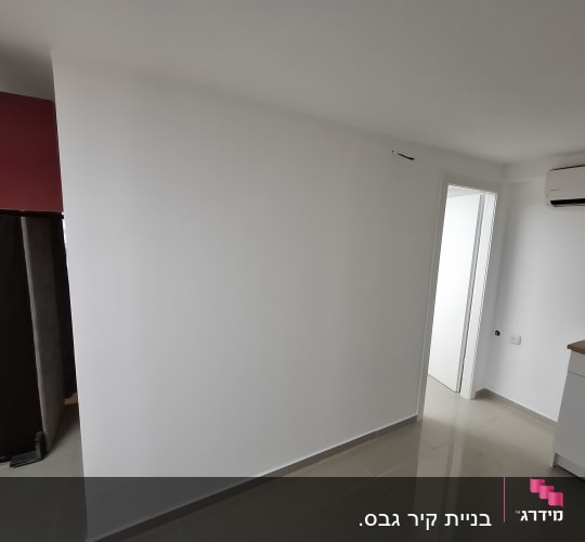 קיר גבס לבן בחדר עם מזגן ודלת פתוחה